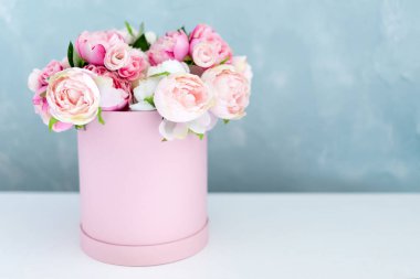 Lüks hediye kutusunda çiçekler. Kağıt kutuda pembe ve beyaz şakayık demeti. Yazı için ücretsiz telif alanı olan şapka kutusu modeli. İç dekorasyon pastel renklerle.