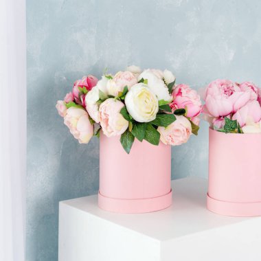 Lüks hediye kutularında çiçekler. Kağıt kutuda pembe ve beyaz şakayık demeti. Yazı için ücretsiz telif alanı olan şapka kutusu modeli. İç dekorasyon pastel renklerle.