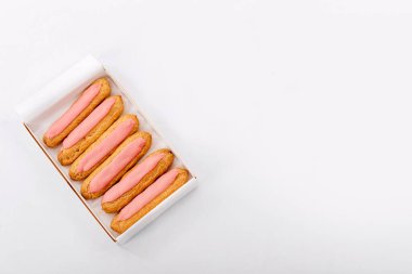 Beyaz arka planda altı tane taze pembe kek olan karton kutuyu aç. Üst görünüm, metin için boşluk. Sağlıksız ya da diyet konsepti