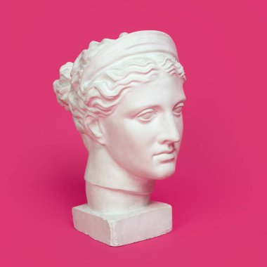 Genç bir kadının mermer kafası, antik Yunan tanrıçası büstü, pembe arka planda izole edilmiş..