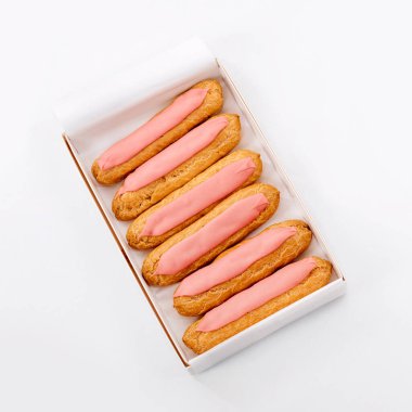 Beyaz arka planda altı tane taze pembe kek olan karton kutuyu aç. Üst Manzara. Sağlıksız ya da diyet konsepti