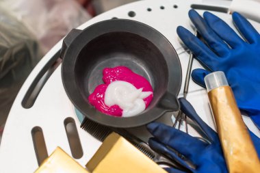 Saç boyası için kuaför aletleri. Kasede saç boyası, saç boyası için eldiven.