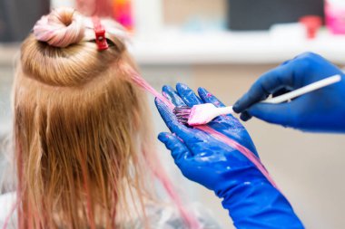 Kuaför kadın saçı ölüyor. Fırçalı eldivenler, kuaförde boyama