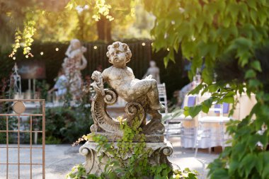 Bahçedeki aşk tanrısı heykeli, açık hava restoranındaki sevimli aşk tanrısı heykeli.