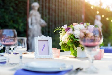 Tatiller ve düğün yemeği için çiçek masası süslemeleri. Açık hava restoranında tatil, etkinlik, parti veya düğün resepsiyonu için masa hazır.