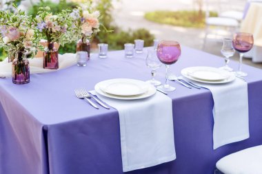 Tatiller ve düğün yemeği için çiçek masası süslemeleri. Açık hava restoranında tatil, etkinlik, parti veya düğün resepsiyonu için masa hazır.