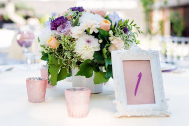 Tatiller ve düğün yemeği için çiçek masası süslemeleri. Açık hava restoranında tatil, etkinlik, parti veya düğün resepsiyonu için masa hazır.