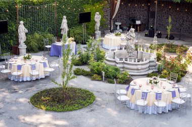 Güzel bir düğün hazırlığı. Bahçede heykel ve fıskiyeli bir düğün.