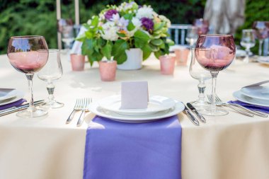 Tatiller ve düğün yemeği için çiçek masası süslemeleri. Açık hava restoranında tatil, etkinlik, parti veya düğün resepsiyonu için masa hazır.