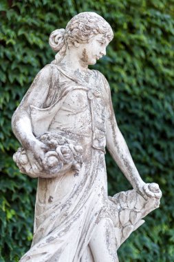 Parkta bir sepet çiçekli mermer heykel kadın.