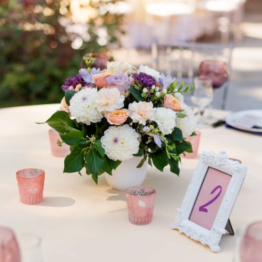 Tatiller ve düğün yemeği için çiçek masası süslemeleri. Açık hava restoranında tatil, etkinlik, parti veya düğün resepsiyonu için masa hazır.