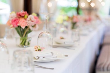 Tatiller ve düğün yemeği için çiçek masası süslemeleri. Açık hava restoranında tatil, etkinlik, parti veya düğün resepsiyonu için masa hazır.