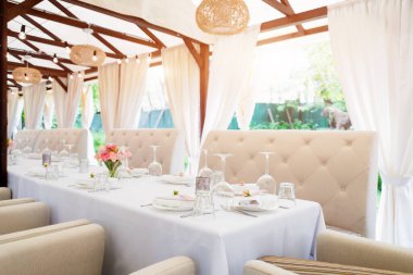 Tatiller ve düğün yemeği için çiçek masası süslemeleri. Açık hava restoranında tatil, etkinlik, parti veya düğün resepsiyonu için masa hazır.