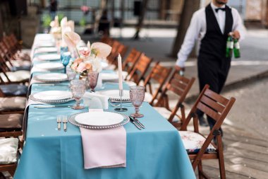 Tatiller ve düğün yemeği için çiçek masası süslemeleri. Açık hava restoranında tatil, etkinlik, parti veya düğün resepsiyonu için masa hazır.