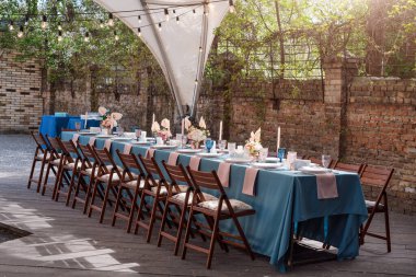 Tatiller ve düğün yemeği için çiçek masası süslemeleri. Açık hava restoranında tatil, etkinlik, parti veya düğün resepsiyonu için masa hazır.