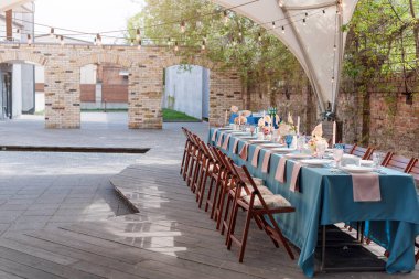 Tatiller ve düğün yemeği için çiçek masası süslemeleri. Açık hava restoranında tatil, etkinlik, parti veya düğün resepsiyonu için masa hazır.