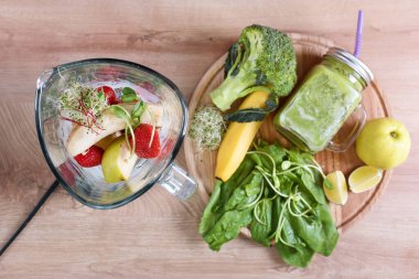 Brokolili, ıspanaklı, mikroyeşillikli, limonlu, muzlu ve ahşap zemin malzemeleriyle dolu bir kavanoz diyet içeceği. Üst Manzara. Detoks, diyet veya sağlıklı gıda konsepti