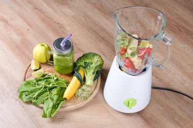 Brokolili, ıspanaklı, mikroyeşillikli, limonlu, muzlu ve ahşap zemin malzemeleriyle dolu bir kavanoz diyet içeceği. Üst Manzara. Detoks, diyet veya sağlıklı gıda konsepti