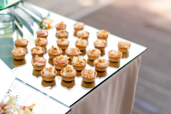 Appetizers, finger food, party food, sliders. Canape, tapas. Served table at summer terrace cafe. Catering service. Outdoor restaurant table with food