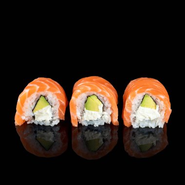 Suşi ruloları taze çiğ somon, krem peynir ve yansımalı siyah üzerine izole edilmiş avokado. Metin için boş alan