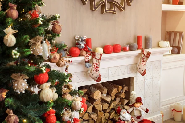 Cozyness and home comfort. Decorated Christmas tree and fireplace with firewood. Winter holidays room interior, Christmas atmosphere