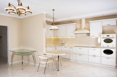 Lüks bir evde modern, parlak, temiz bir mutfak. Klasik veya klasik elementlerle iç tasarım. Pratik ve iyi döşenmiş mutfak.