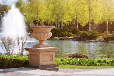 Göl, çiçek açan çalılar ve çeşmelerle süslü bahçeler..