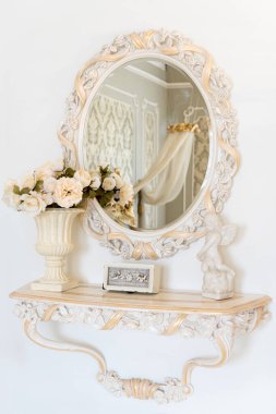 Lüks yatak odasının duvarları açık renkli ve aynalı. Zarif klasik iç mekan..