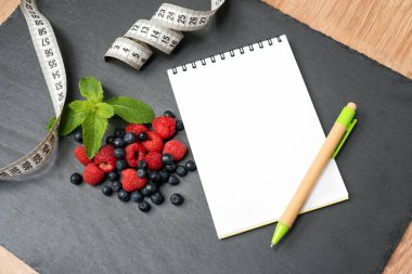 Yabanmersini, ahududu, nane, mezura, not ve notlar yazmak için not defteri, spor, diyet, zayıflama, detoks, sağlıklı yaşam tarzları ve beslenme konsepti. Metin için boşluk oluştur