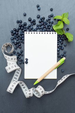 Yaban mersini, nane yaprağı ve notlar yazmak için not defteri, spor konsepti, diyet, zayıflama, detoks, sağlıklı yaşam biçimleri ve beslenme. Metin için boşluk oluştur