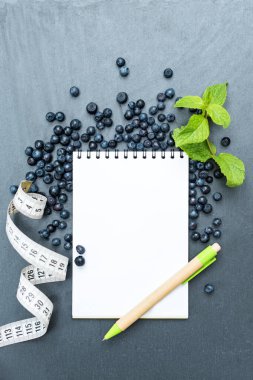 Yaban mersini, nane yaprağı ve notlar yazmak için not defteri, spor konsepti, diyet, zayıflama, detoks, sağlıklı yaşam biçimleri ve beslenme. Metin için boşluk oluştur