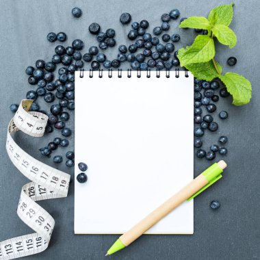 Yaban mersini, nane yaprağı ve notlar yazmak için not defteri, spor konsepti, diyet, zayıflama, detoks, sağlıklı yaşam biçimleri ve beslenme. Metin için boşluk oluştur