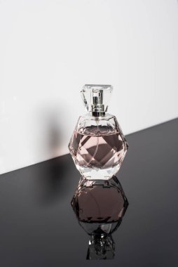 Beyaz arka planda yansıması olan parfüm şişesi. Parfüm, kozmetik