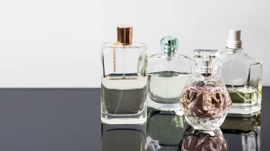 Yansımalı farklı parfüm şişeleri. Parfüm, kozmetik. Metin için boş alan.