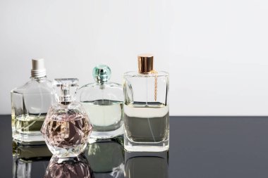 Yansımalı farklı parfüm şişeleri. Parfüm, kozmetik. Metin için boş alan.