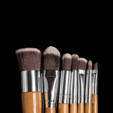 Metin için alanı olan siyah arkaplan üzerine profesyonel makyaj fırçaları koleksiyonu.