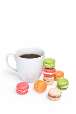 Beyaz arka planda bir fincan kahveli tatlı ve renkli badem kurabiyeleri. Geleneksel Fransız tatlı kurabiyeleri, metin için yer.