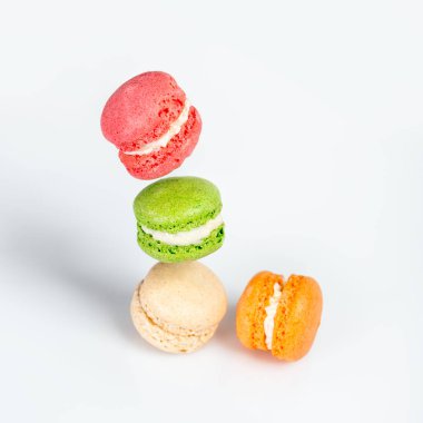 Beyaz arka planda hareket eden farklı türde badem kurabiyeleri. Geleneksel Fransız tatlısı beyaz üzerine izole edilmiş ve yazı için yeri var.