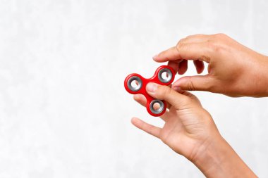 Fidget fırıldağı. Kırmızı el çabukluğu, kıpır kıpır oyuncaklarla oynayan çocuklar. Stres atmak. Stres önleyici ve rahatlatıcı. İlgi çekici çocuk konsepti. Metin için boş alan