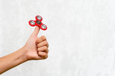 Fidget fırıldağı. Kırmızı el çevirici, titrek el oyuncağı çocuğun elinde dönüyor. Stres atmak. Stres önleyici ve rahatlatıcı. İlgi çekici çocuk konsepti. Metin için boş alan