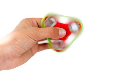Fidget fırıldağı. Kırmızı el çevirici, titrek el oyuncağı çocuğun elinde dönüyor. Stres atmak. Stres önleyici ve rahatlatıcı. İlgi çekici çocuk konsepti.