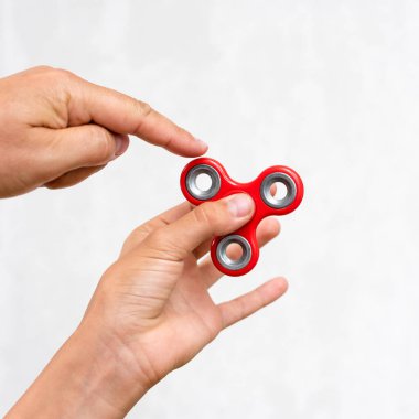 Fidget fırıldağı. Kırmızı el çabukluğu, kıpır kıpır oyuncaklarla oynayan çocuklar. Stres atmak. Stres önleyici ve rahatlatıcı. İlgi çekici çocuk konsepti.
