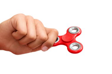 Kırmızı el hareketi. Çocuk elinde popüler bir oyuncak fırıldağı oynuyor. Stres atmak. Stres önleyici ve rahatlatıcı. İlgi çekici çocuk konsepti.