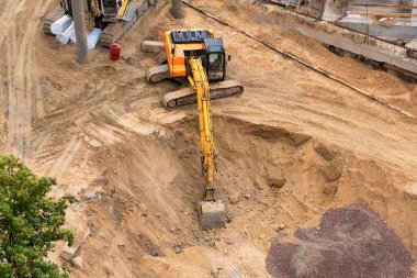 Yeni binanın beton temelinin inşası. İnşaat makineleri, kazıcı, üst görünüm.
