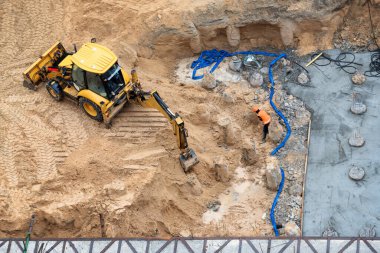Yeni binanın beton temelinin inşası. İnşaat makineleri, kazıcı, üst görünüm.