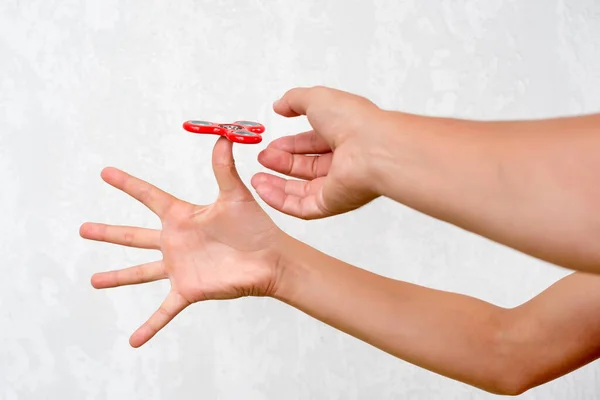 Fidget spinner. Red hand spinner, boys playing with fidgeting hand toy. Stress relief. Anti stress and relaxation adhd attention fad boy concept