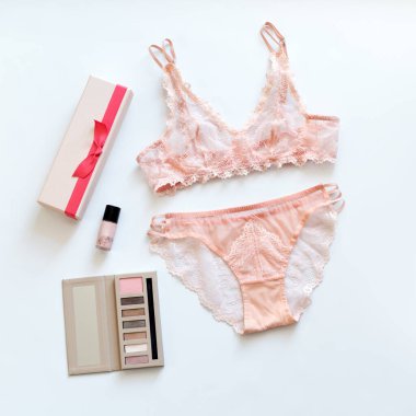 Alışveriş ve moda konsepti. Kozmetik ürünleri ve beyaz arka planda kadın aksesuarları olan göz kamaştırıcı, seksi dantelli iç çamaşırları. Üst bakış açısı, düz yatış.