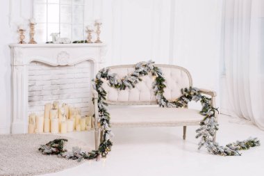Şöminesi, kanepesi ve Noel süslemeleri olan beyaz klasik iç mekan.