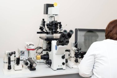 Doktor ya da bilim adamı biyoteknoloji laboratuvarında bilgisayar ve mikroskopla çalışıyor. Döllenme laboratuvarında ekipman, tüp bebek.