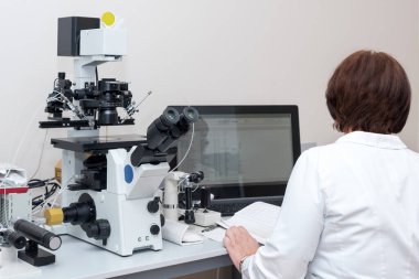 Doktor ya da bilim adamı biyoteknoloji laboratuvarında bilgisayar ve mikroskopla çalışıyor. Döllenme laboratuvarında ekipman, tüp bebek.